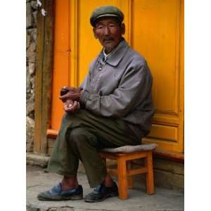 Man Sitting on Stool on Sidewalk, Looking at Camera, Baisha, China Art 