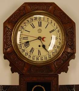 New Haven wall clock carved oak case eglomised glass orginal dial 