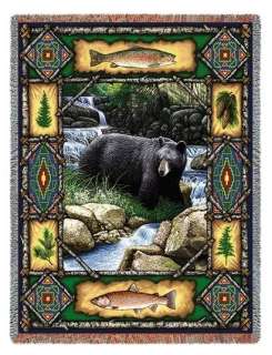 majestic black bear stands by a stream. He is framed by rustic lodge 